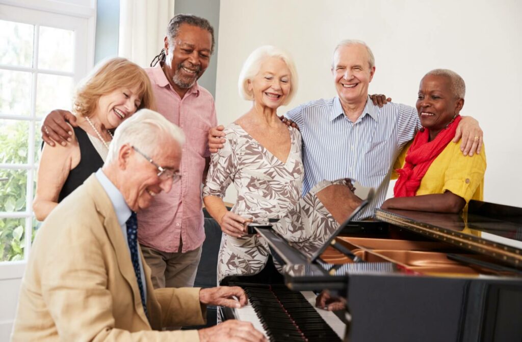 A group of older adults enjoying a group music therapy session with a piano.