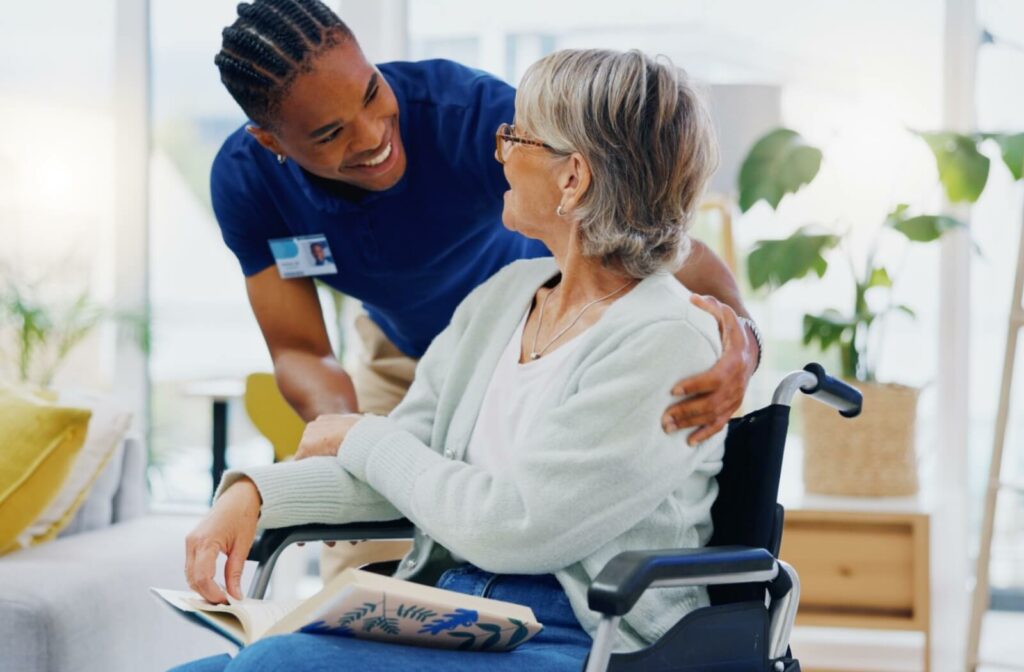 A caregiver personally looks after an older woman in a wheelchair.
