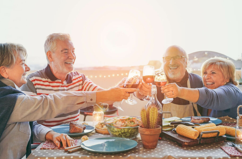 A group of older adults sharing a fancy meal outdoors.